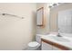 Well-lit bathroom featuring a wood-trimmed vanity, toilet, and recessed medicine cabinet at 320 Summerwalk Cir, Chapel Hill, NC 27517