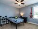 A cozy bedroom featuring blue walls, ceiling fan, and drumset at 33 Northlodge Ct, Wendell, NC 27591