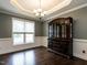 Elegant dining room boasts hardwood floors, wainscoting, and a tray ceiling with chandelier at 33 Northlodge Ct, Wendell, NC 27591