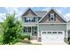 Two-story home with an attached garage, inviting front porch, and a well-maintained lawn at 33 Northlodge Ct, Wendell, NC 27591