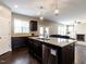 Open kitchen with granite island and stainless steel dishwasher flowing into the living room with a fireplace at 33 Northlodge Ct, Wendell, NC 27591
