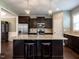 Modern kitchen with granite countertops, stainless steel appliances, dark cabinetry, and pendant lighting at 33 Northlodge Ct, Wendell, NC 27591