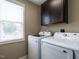 Laundry room features modern Samsung washer and dryer and dark cabinets at 33 Northlodge Ct, Wendell, NC 27591