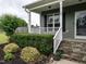 Inviting front porch with stone steps, white railings, and lush landscaping offering a warm welcome at 33 Northlodge Ct, Wendell, NC 27591