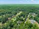 Aerial view showcases the property surrounded by lush greenery, a golf course, and neighborhood at 3307 Devon Rd, Durham, NC 27707