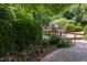 Outdoor dining area on a brick patio surrounded by lush landscaping and vibrant flowers at 3307 Devon Rd, Durham, NC 27707