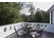 Outdoor balcony features a table and chairs, offering a peaceful view of the surrounding greenery at 3307 Devon Rd, Durham, NC 27707