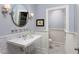 Stylish powder bathroom with a marble top vanity and a coordinating circular mirror at 3307 Devon Rd, Durham, NC 27707