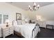 Bedroom featuring an iron bed frame, neutral tones, a chandelier, and white dresser at 3307 Devon Rd, Durham, NC 27707