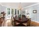 Elegant dining room with hardwood floors, chandelier, decorative rug, and doors leading to the pool at 3307 Devon Rd, Durham, NC 27707