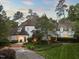 Beautiful home with exterior lighting, lush landscaping, and a winding driveway creating a warm and inviting ambiance at 3307 Devon Rd, Durham, NC 27707