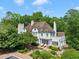 Stunning aerial view of an elegant white brick home surrounded by lush greenery and a charming brick patio at 3307 Devon Rd, Durham, NC 27707