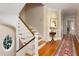 Bright foyer featuring hardwood floors, staircase with wooden banister, and a round window at 3307 Devon Rd, Durham, NC 27707