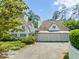 Spacious three-car garage attached to an elegant home with a beautifully landscaped yard and driveway at 3307 Devon Rd, Durham, NC 27707