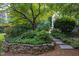 Beautiful yard with lush greenery, hydrangea bushes, and a stone walkway at 3307 Devon Rd, Durham, NC 27707