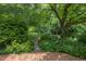 Landscaped backyard featuring brick path, foliage and a garden gate at 3307 Devon Rd, Durham, NC 27707