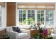 Bright living room showcasing white armchair, orchid plants and a window view of the backyard at 3307 Devon Rd, Durham, NC 27707