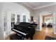 Elegant piano room with natural light and an grand piano, flowing seamlessly into the adjacent living spaces at 3307 Devon Rd, Durham, NC 27707