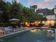 An outdoor pool is surrounded by lounge chairs for relaxing in the sun in the evening at 3307 Devon Rd, Durham, NC 27707