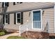 Close up of the front of the house with blue door, white railings, and green lawn at 3317 E Jameson Rd, Raleigh, NC 27604