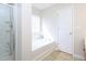 Bright bathroom featuring a shower, tub, and a large window at 3515 Mountain Brook Cir, Durham, NC 27704
