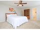 Carpeted bedroom featuring a ceiling fan, a bed with white comforter, and two built in shelves at 3515 Mountain Brook Cir, Durham, NC 27704