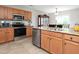 Well-lit kitchen with stainless steel appliances, wooden cabinets, and granite countertops offers ample workspace at 3515 Mountain Brook Cir, Durham, NC 27704