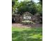 Landscaped entrance to Stillwood, featuring a stone sign and colorful flowerbed at 3515 Mountain Brook Cir, Durham, NC 27704