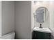 Powder room featuring modern fixtures, a sleek vanity, and a stylish round mirror at 3720 Jamestown Cir, Raleigh, NC 27609