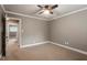 This bedroom has neutral walls, carpet flooring, a ceiling fan, and a view to an adjoining room at 3720 Jamestown Cir, Raleigh, NC 27609