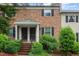 Charming two-story brick townhouse with black shutters, landscaped yard, and covered front porch at 3720 Jamestown Cir, Raleigh, NC 27609