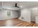 Living room showcasing wood floors, modern fan, and closet with laundry hookups at 3720 Jamestown Cir, Raleigh, NC 27609