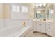 Bright bathroom features a soaking tub, white cabinetry, and tiled floor at 3928 Bentley Bridge Rd, Raleigh, NC 27612