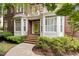 Charming brick home with a bright green front door, bay windows and manicured landscaping creating a welcoming entrance at 3928 Bentley Bridge Rd, Raleigh, NC 27612