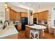 Well-equipped kitchen with stainless steel appliances, a central island with cooktop, and wooden cabinets at 3928 Bentley Bridge Rd, Raleigh, NC 27612