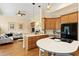 Open kitchen with wooden cabinetry, black appliances, and view into the cozy living room at 3928 Bentley Bridge Rd, Raleigh, NC 27612