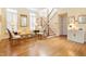 Light-filled living room with hardwood floors, staircase, comfortable seating, and large windows with plantation shutters at 3928 Bentley Bridge Rd, Raleigh, NC 27612
