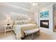 Comfortable main bedroom featuring a tray ceiling, fireplace, and elegant furnishings at 3928 Bentley Bridge Rd, Raleigh, NC 27612