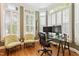 Bright home office with hardwood floors, a glass top desk, and multiple windows with plantation shutters at 3928 Bentley Bridge Rd, Raleigh, NC 27612