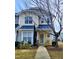 Charming two-story home with a blue metal roof, lovely landscaping, and a welcoming front porch with decorative wreath at 4202 Cherry Blossom Cir, Durham, NC 27713
