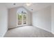 Bright bedroom featuring large arched window and french doors leading to balcony at 425 Faith Dr, Gibsonville, NC 27249