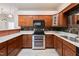 This kitchen features wood cabinetry, granite countertops and stainless steel appliances at 425 Faith Dr, Gibsonville, NC 27249