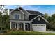 Charming two-story home featuring a covered porch, gray siding, and an attached two-car garage at 547 Claftin St, Sanford, NC 27330