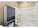 Clean bathroom featuring a white tub and shower combination with a gray storage cabinet at 5910 Giddings St, Raleigh, NC 27616