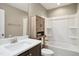 Well lit bathroom with vanity, wood storage cabinet, and shower-tub combo at 5910 Giddings St, Raleigh, NC 27616