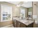 Bathroom with double vanities, granite countertops, large mirror, and natural light at 5910 Giddings St, Raleigh, NC 27616