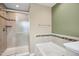 Bathroom featuring a glass shower, soaking tub, and decorative tile accents at 5910 Giddings St, Raleigh, NC 27616