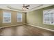 Spacious bedroom with hardwood floors, tray ceiling, ceiling fan, and large windows at 5910 Giddings St, Raleigh, NC 27616