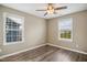 Bedroom featuring hardwood floors, ceiling fan, and natural light from two large windows at 5910 Giddings St, Raleigh, NC 27616