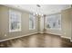 Well-lit dining room with hardwood floors, modern chandelier, and scenic windows at 5910 Giddings St, Raleigh, NC 27616